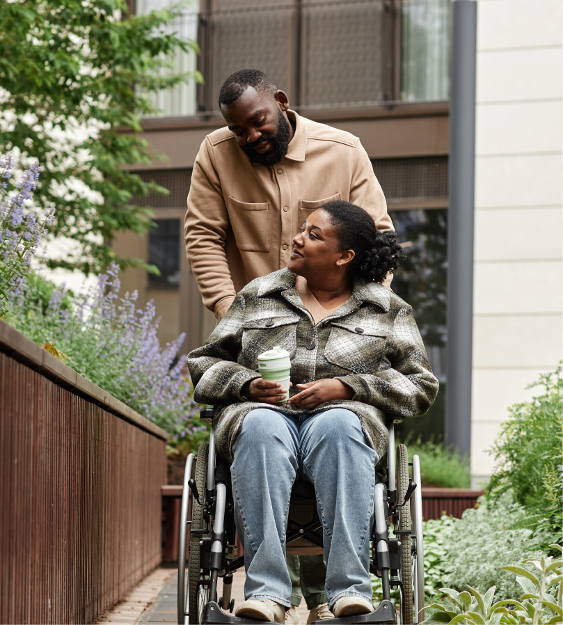 Husband Pushing Wife In Wheel Chair Husband Pushing Wife In Wheel Chair